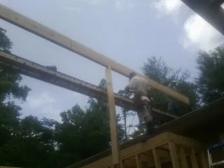 Carpenter setting a ridge beam over a new addition frame — Ice Dam Removal by Roofing Brothers in Kansas