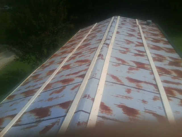 Rusted metal roof panels with new wood purlins before replacement — Storm Damage Roof Repair in Kansas by Roofing Brothers