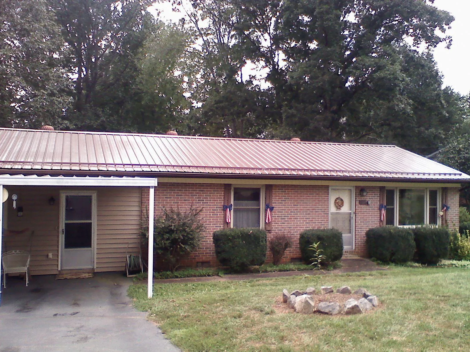Bronze metal roof and carport on a brick ranch home — Roof Repair work by our crew in Kansas